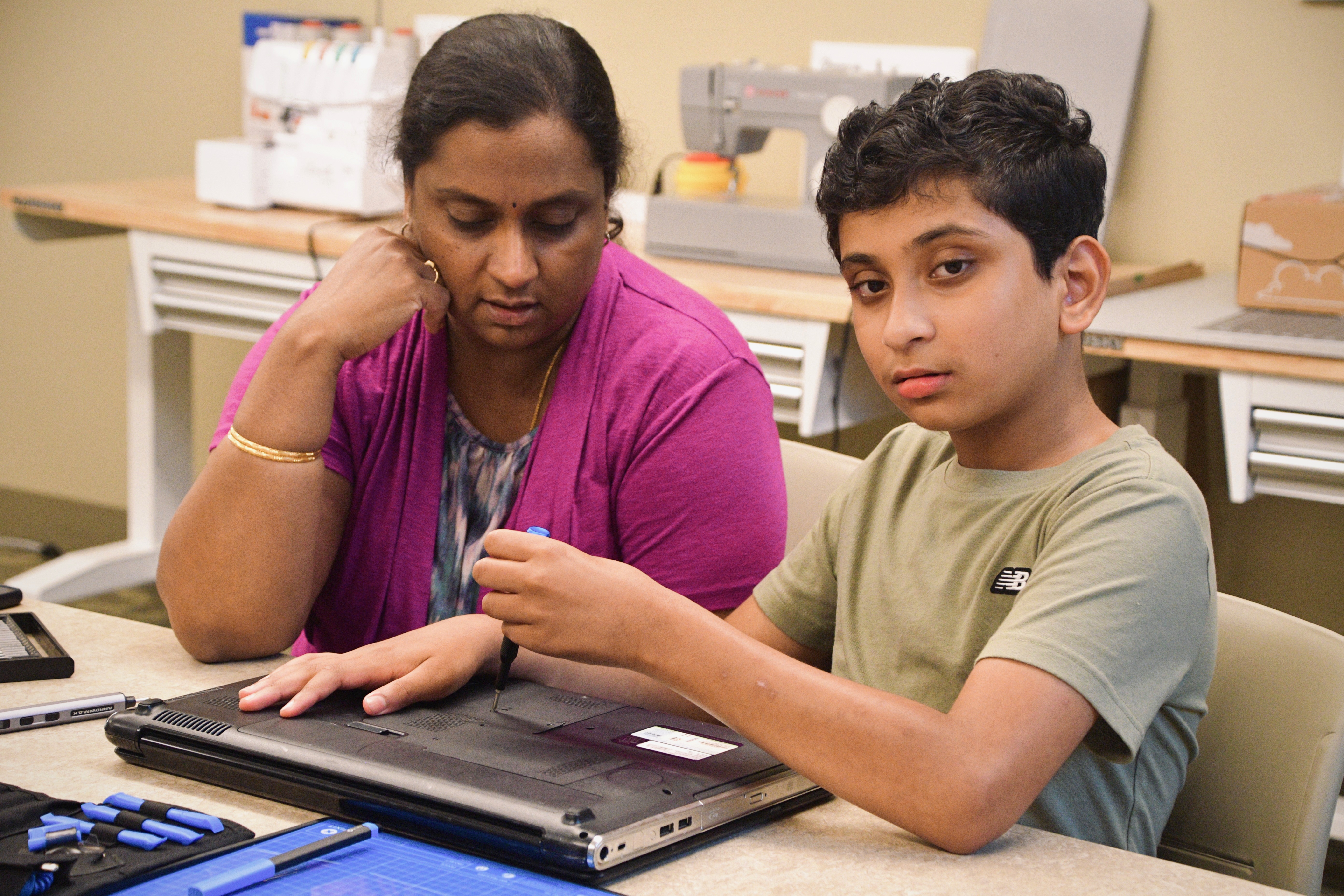 A parent and student opening a laptop together
