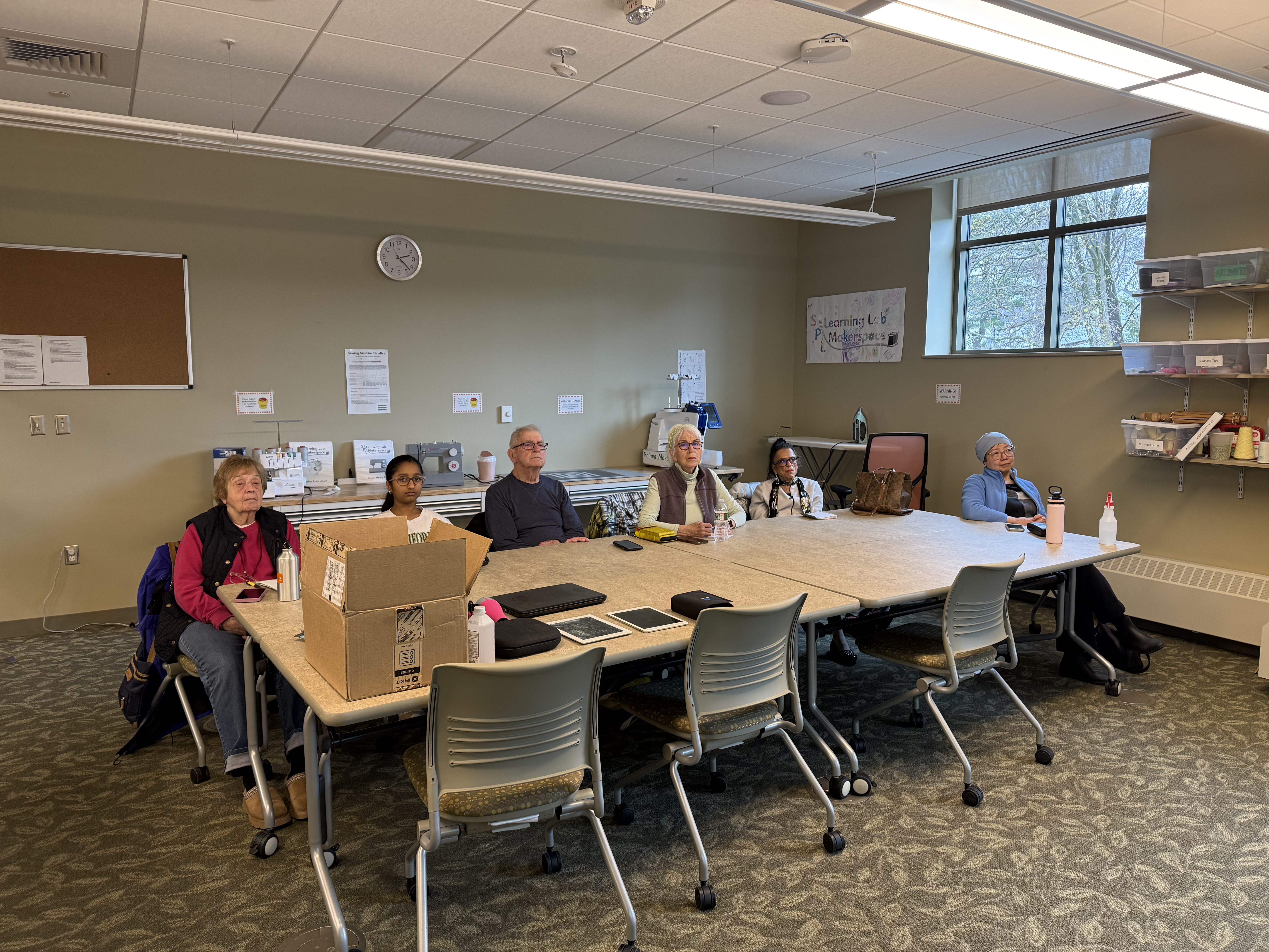 A group of community members seated around the workshop table