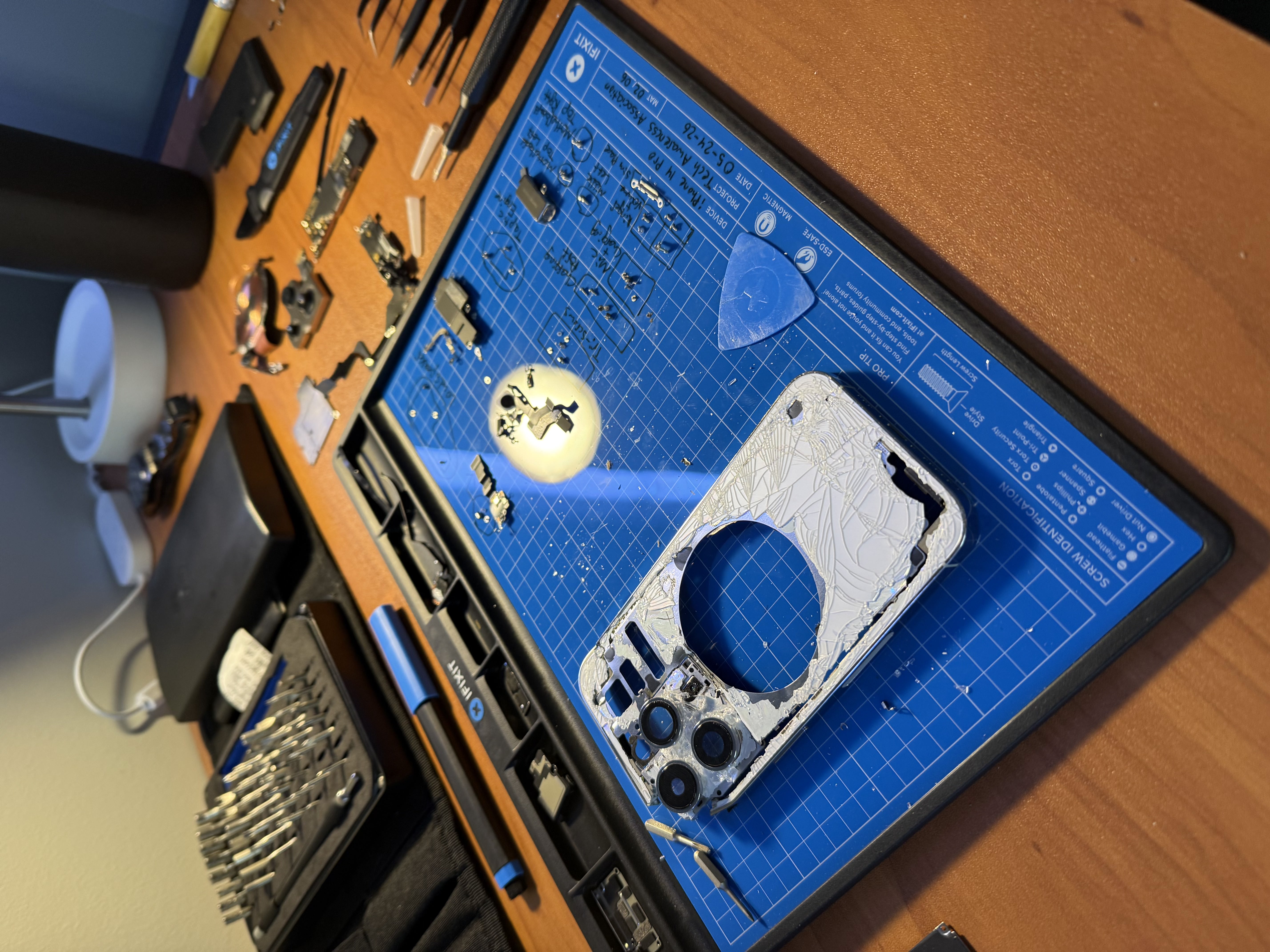 A disassembled iPhone on an iFixit repair mat labelled Tech Awareness Association